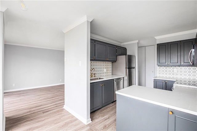 2525 Main St Unit 305, Kansas City, MO 64108 - kitchen with light wood finished floors, decorative backsplash, light countertops, stainless steel appliances, and crown molding