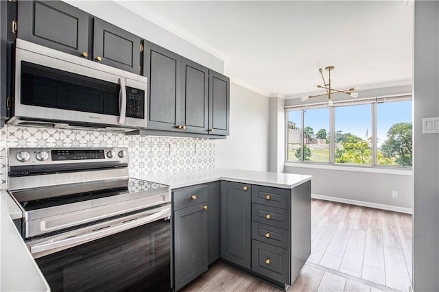 2525 Main St Unit 305, Kansas City, MO 64108 - kitchen with stainless steel appliances, a peninsula, decorative backsplash, ornamental molding, and light countertops
