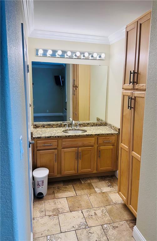 700 E 8th St Unit 4J, Kansas City, MO 64106 - bathroom with stone tile floors, vanity, and crown molding