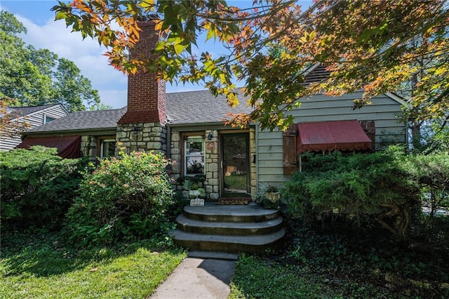 5147 Maple Ave, Mission, KS 66202 - view of front of house featuring a chimney, stone siding, and a shingled roof