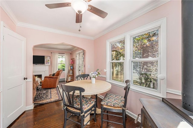 5147 Maple Ave, Mission, KS 66202 - dining space with arched walkways, dark wood-type flooring, a fireplace, ornamental molding, and ceiling fan