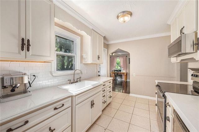 5147 Maple Ave, Mission, KS 66202 - kitchen with stainless steel appliances, arched walkways, backsplash, light countertops, and light tile patterned floors