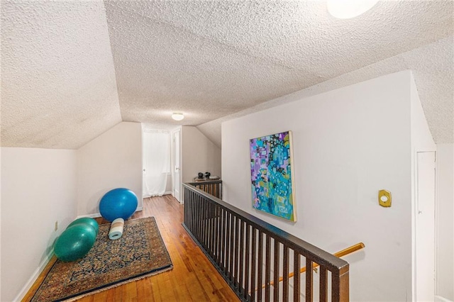 5147 Maple Ave, Mission, KS 66202 - corridor featuring an upstairs landing, a textured ceiling, hardwood / wood-style floors, and lofted ceiling