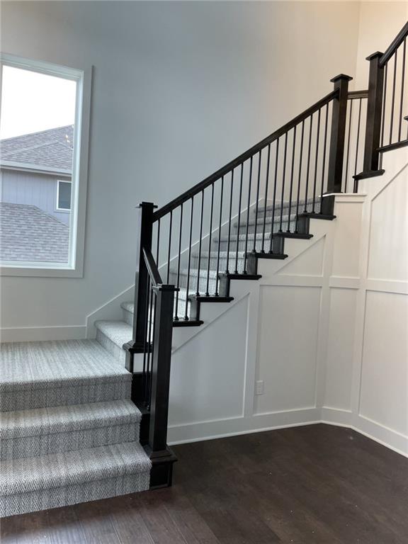 9015 N Colorado Ave, Kansas City, MO 64156 - staircase featuring wood finished floors and a decorative wall