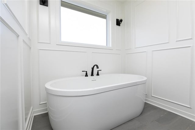 9015 N Colorado Ave, Kansas City, MO 64156 - bathroom featuring a decorative wall, a freestanding tub, and tile patterned flooring