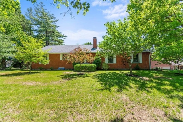 601 Darrow St, Warrensburg, MO 64093 - back of property featuring a yard, a chimney, and brick siding