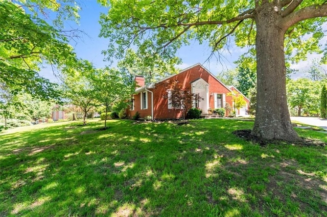 601 Darrow St, Warrensburg, MO 64093 - view of home's exterior with a chimney and a lawn