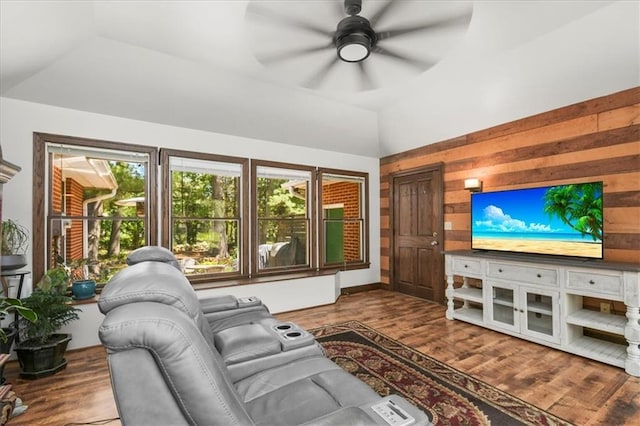 601 Darrow St, Warrensburg, MO 64093 - living room featuring vaulted ceiling, wooden walls, ceiling fan, and wood finished floors