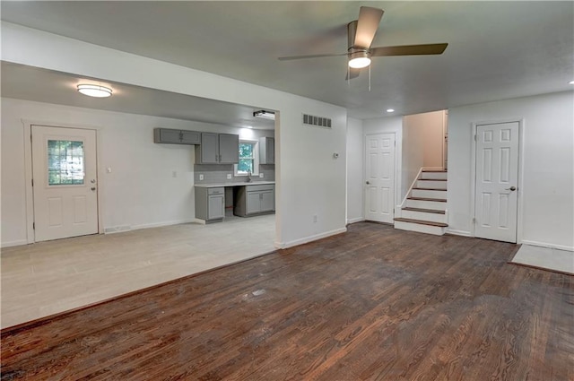 12825 E 50th Ter S, Independence, MO 64055 - unfurnished living room with wood finished floors, ceiling fan, and stairs