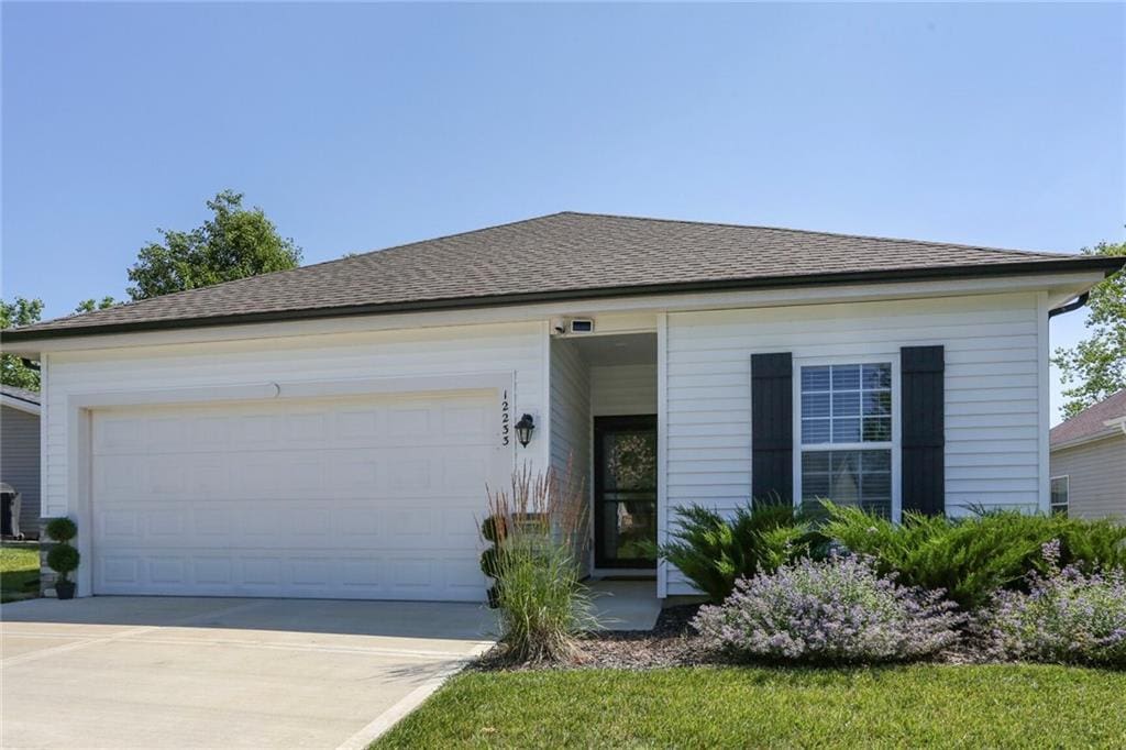 12233 N Pomona Ave, Kansas City, MO 64163 - single story home featuring concrete driveway, a garage, and roof with shingles