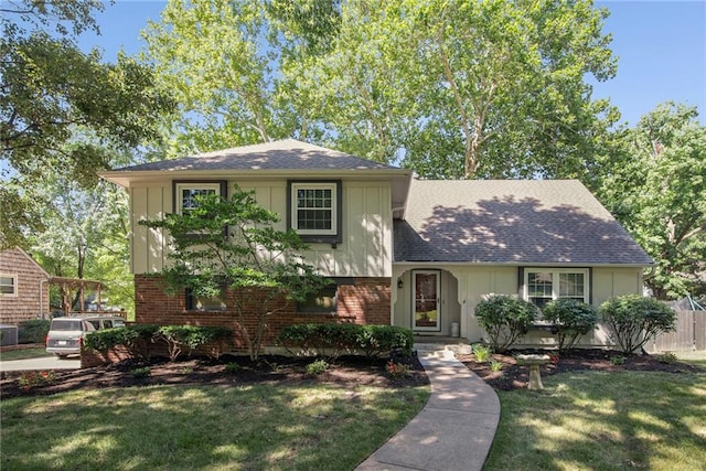 9934 Ballentine Dr, Overland Park, KS 66214 - split level home with a front yard, brick siding, roof with shingles, and board and batten siding