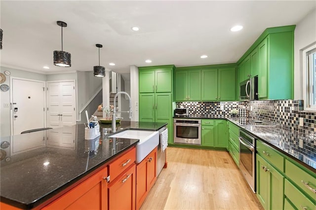 9934 Ballentine Dr, Overland Park, KS 66214 - kitchen with stainless steel appliances, light wood-type flooring, decorative backsplash, dark stone counters, and recessed lighting
