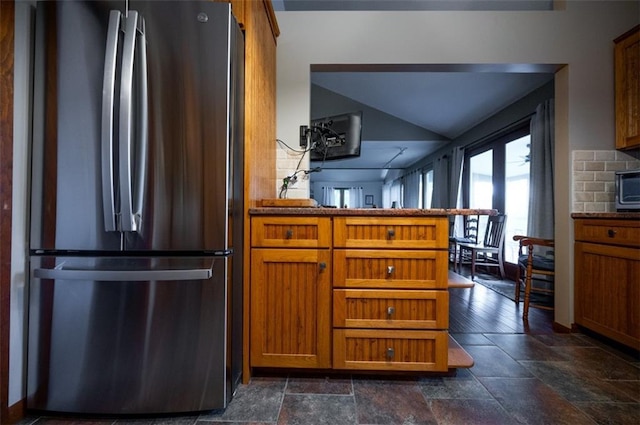 8231 Mike O Vince Rd, Ozawkie, KS 66070 - kitchen featuring freestanding refrigerator, brown cabinetry, stone tile floors, a peninsula, and vaulted ceiling