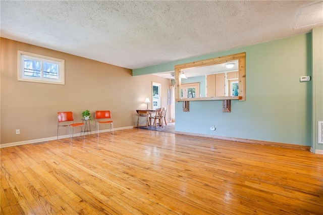 1504 Oak Hill Ave, Lawrence, KS 66044 - spare room featuring a textured ceiling, wood-type flooring, and healthy amount of natural light
