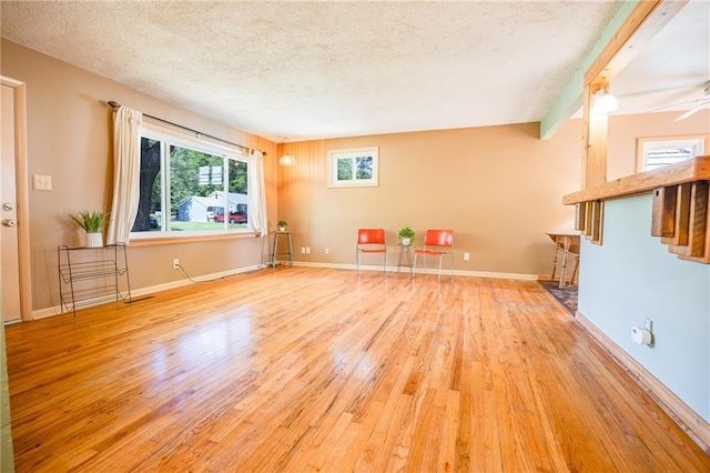 1504 Oak Hill Ave, Lawrence, KS 66044 - unfurnished living room featuring wood finished floors, a textured ceiling, and a ceiling fan