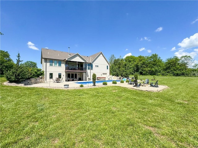 21219 S Coleman Rd, Peculiar, MO 64078 - rear view of property with a patio area, a fire pit, an outdoor pool, a balcony, and a lawn