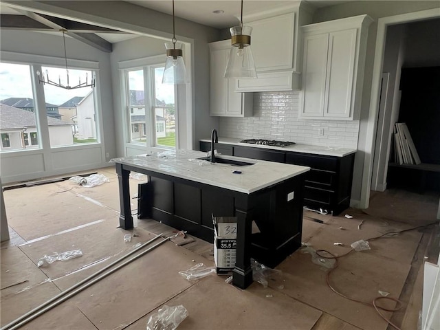 1709 SW Arbor Park Dr, Lees Summit, MO 64082 - kitchen with tasteful backsplash, an island with sink, white cabinets, and hanging light fixtures
