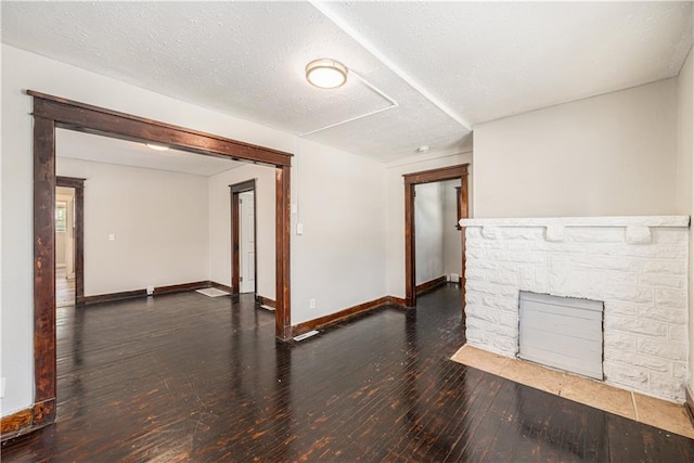 3842 E 68th Ter, Kansas City, MO 64132 - unfurnished living room featuring hardwood / wood-style floors and a stone fireplace