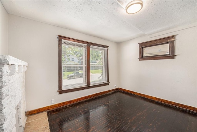 3842 E 68th Ter, Kansas City, MO 64132 - empty room featuring a textured ceiling and hardwood / wood-style flooring
