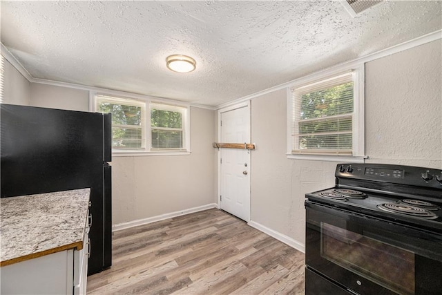 3842 E 68th Ter, Kansas City, MO 64132 - kitchen with black appliances, a textured ceiling, light wood finished floors, light countertops, and healthy amount of natural light
