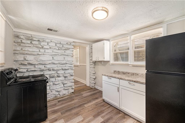 3842 E 68th Ter, Kansas City, MO 64132 - kitchen featuring black appliances, a textured ceiling, white cabinets, light wood-style flooring, and ornamental molding