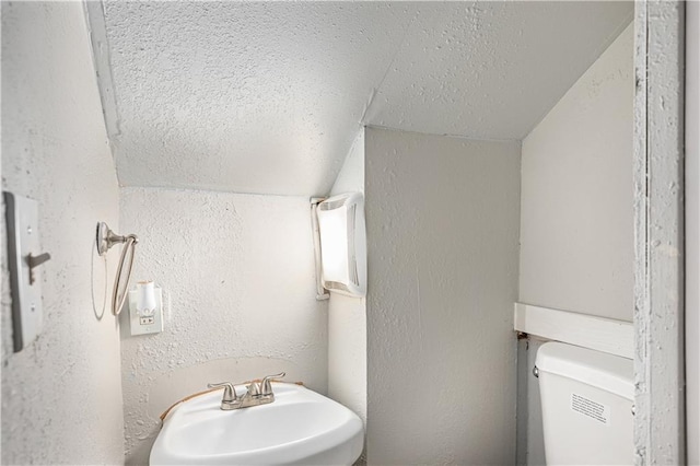 3842 E 68th Ter, Kansas City, MO 64132 - bathroom featuring vaulted ceiling, a textured wall, and a textured ceiling