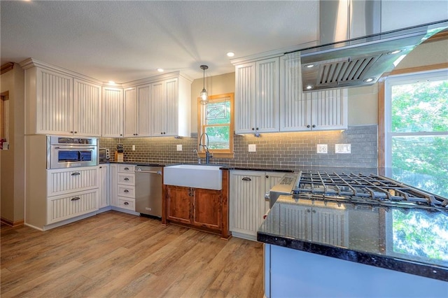 22 Emerald Shore Dr, Lake Tapawingo, MO 64015 - kitchen featuring stainless steel appliances, wall chimney range hood, light wood-style flooring, tasteful backsplash, and recessed lighting
