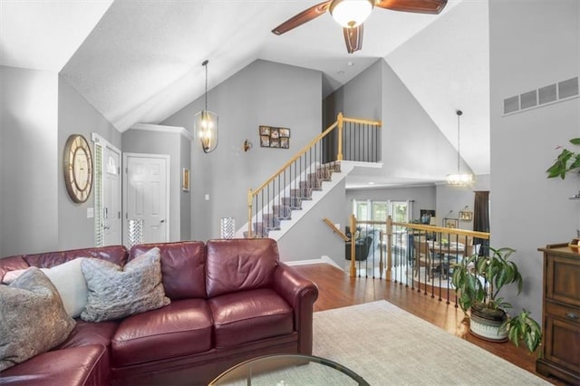 2125 SW Post Oak Rd, Lees Summit, MO 64082 - living room with wood finished floors, a ceiling fan, high vaulted ceiling, stairway, and a chandelier