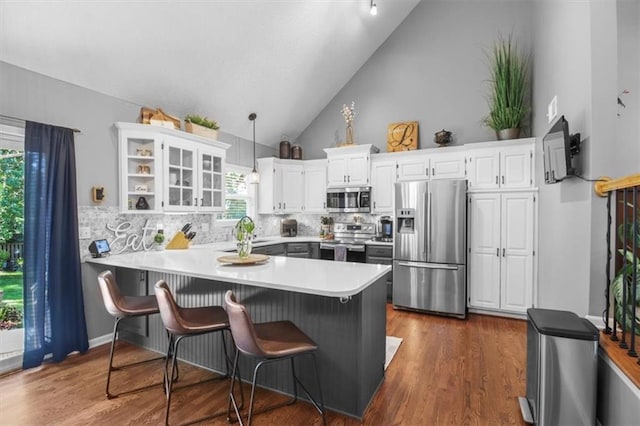 2125 SW Post Oak Rd, Lees Summit, MO 64082 - kitchen featuring stainless steel appliances, a peninsula, lofted ceiling, white cabinets, and decorative backsplash