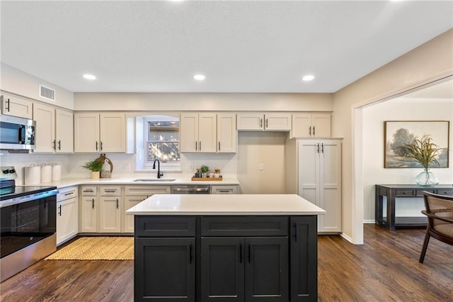 1424 E Meadow Ln, Olathe, KS 66062 - kitchen featuring stainless steel appliances, light countertops, dark wood finished floors, a kitchen island, and recessed lighting