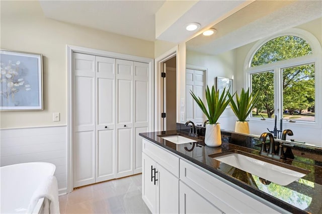 1424 E Meadow Ln, Olathe, KS 66062 - bathroom with double vanity, a freestanding tub, a closet, and recessed lighting