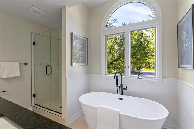 1424 E Meadow Ln, Olathe, KS 66062 - full bathroom with a shower stall, a freestanding tub, wainscoting, and tile walls