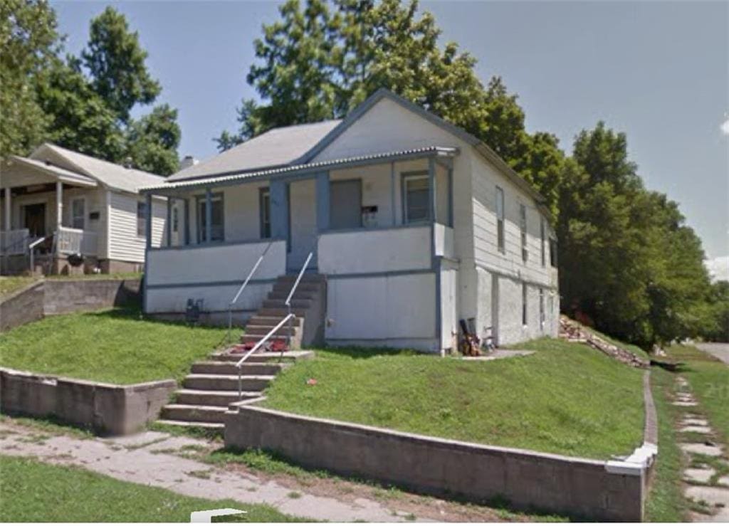 2001 Main St, Saint Joseph, MO 64505 - view of front of home featuring stairs, a porch, and a front yard