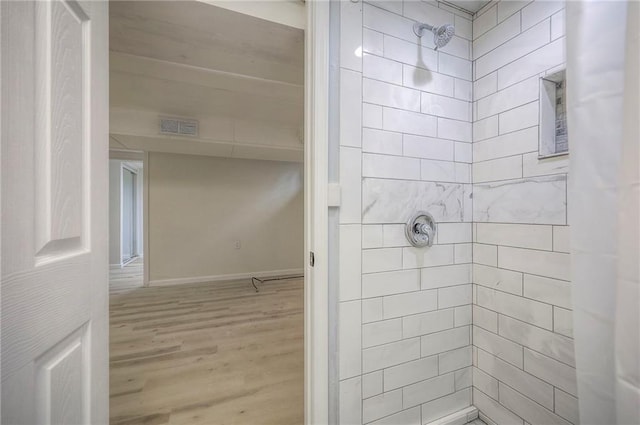6605 Willow Ave, Raytown, MO 64133 - bathroom featuring a tile shower and wood finished floors
