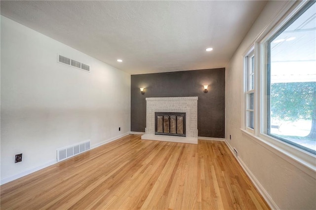 6605 Willow Ave, Raytown, MO 64133 - unfurnished living room featuring light wood-style flooring, a fireplace, and recessed lighting