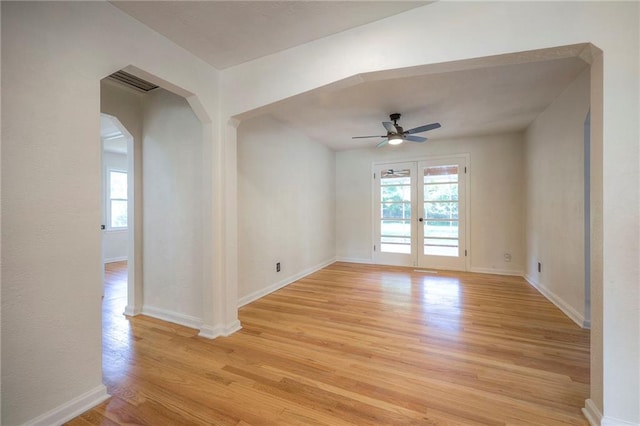 6605 Willow Ave, Raytown, MO 64133 - spare room featuring light wood finished floors, a ceiling fan, french doors, and arched walkways