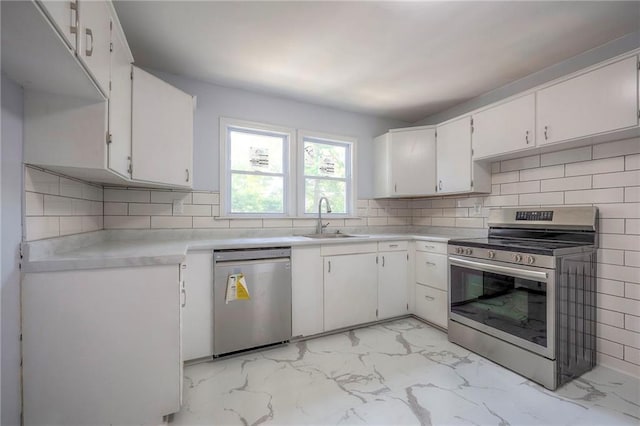 6605 Willow Ave, Raytown, MO 64133 - kitchen featuring stainless steel appliances, light marble finish floors, white cabinets, light countertops, and backsplash