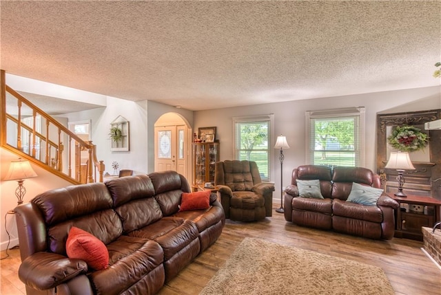 440 41p Rd, Clinton, MO 64735 - living area with arched walkways, wood finished floors, stairs, and a textured ceiling