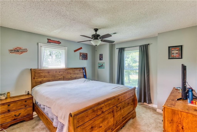 440 41p Rd, Clinton, MO 64735 - bedroom featuring light colored carpet, multiple windows, ceiling fan, and a textured ceiling