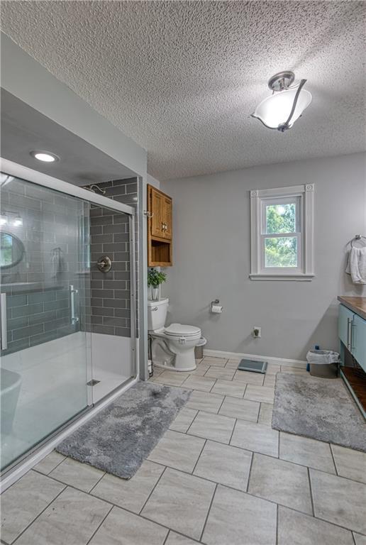 440 41p Rd, Clinton, MO 64735 - bathroom with a textured ceiling, a shower stall, and vanity