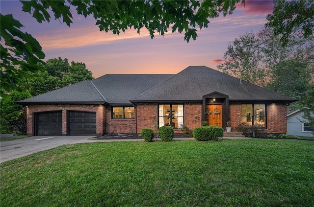 12419 Askew Dr, Grandview, MO 64030 - view of front of home featuring an attached garage, a front lawn, brick siding, and driveway