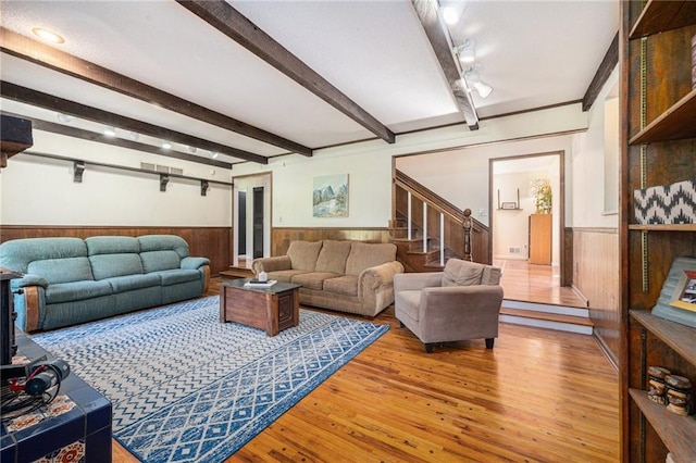12419 Askew Dr, Grandview, MO 64030 - living area featuring wainscoting, wood finished floors, stairway, beamed ceiling, and wood walls