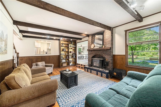 12419 Askew Dr, Grandview, MO 64030 - living room with a wainscoted wall, wood walls, wood finished floors, beam ceiling, and ceiling fan