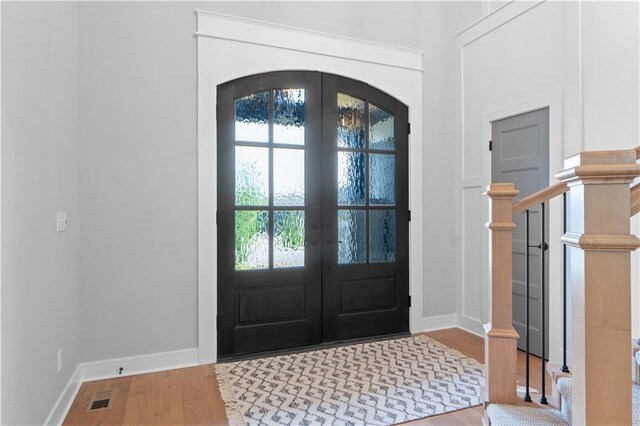23717 W 118th Ter, Olathe, KS 66061 - foyer featuring french doors, arched walkways, wood finished floors, and stairs