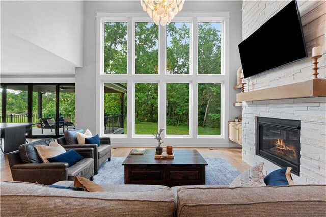 23717 W 118th Ter, Olathe, KS 66061 - living area with a high ceiling, a stone fireplace, a chandelier, and wood finished floors