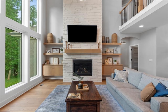 23717 W 118th Ter, Olathe, KS 66061 - living area featuring a fireplace, a high ceiling, and light wood-style flooring