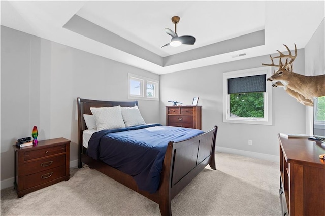 23717 W 118th Ter, Olathe, KS 66061 - bedroom featuring a raised ceiling, light colored carpet, multiple windows, and a ceiling fan