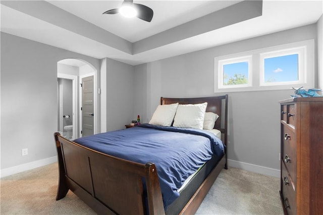 23717 W 118th Ter, Olathe, KS 66061 - bedroom featuring arched walkways, light carpet, a tray ceiling, and connected bathroom