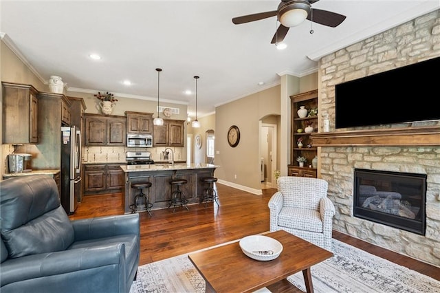 1415 SW Antiquity Dr, Lees Summit, MO 64081 - living room with arched walkways, a ceiling fan, a fireplace, dark wood-style flooring, and recessed lighting