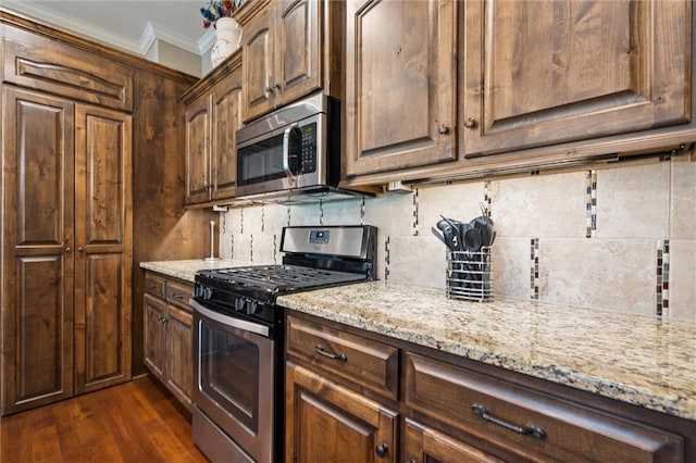 1415 SW Antiquity Dr, Lees Summit, MO 64081 - kitchen featuring appliances with stainless steel finishes, crown molding, light stone countertops, decorative backsplash, and dark wood-type flooring